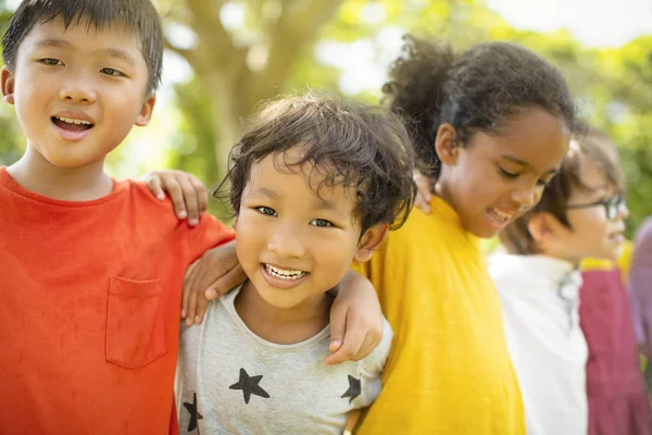 Multiethnische Gruppe von Schulkindern, die lachen und sich umarmen — Stockfoto