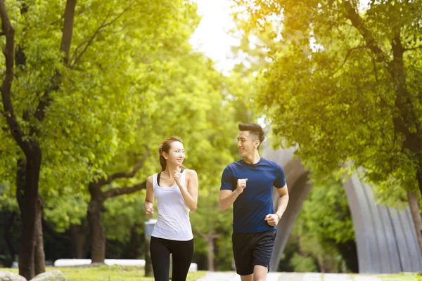 Heureux jeune couple jogging et courir dans le parc — Photo