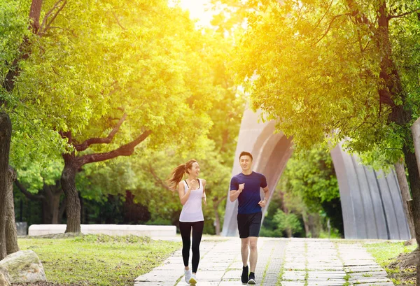 Feliz joven pareja trotando y corriendo en parque — Foto de Stock