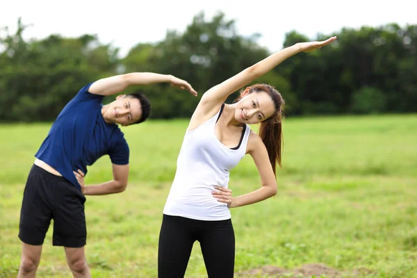 Jeune couple sportif travaillant ensemble à l'extérieur — Photo