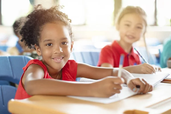 Усміхнені діти початкової школи в класі — стокове фото