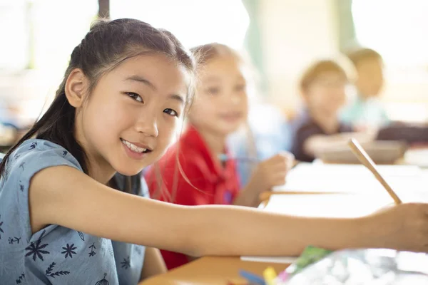 Crianças do ensino fundamental sorridentes em sala de aula — Fotografia de Stock