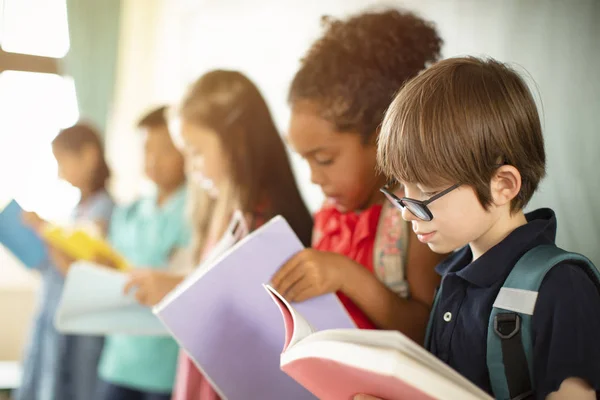 Gruppo di giovani studenti diversi che studiano in classe — Foto Stock