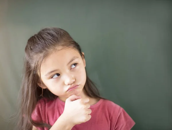 Niña de pie sobre el fondo de pizarra — Foto de Stock