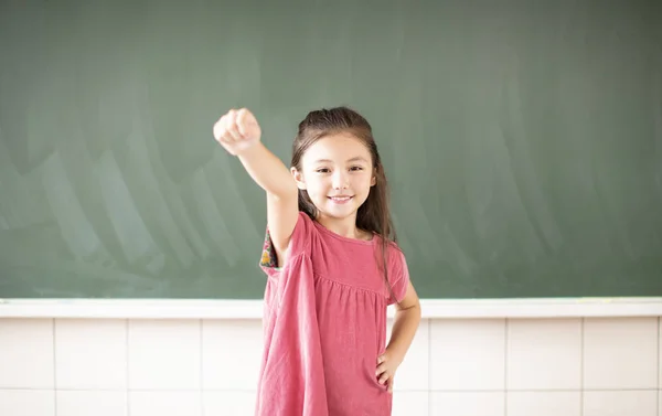 Menina feliz de pé contra o fundo quadro — Fotografia de Stock