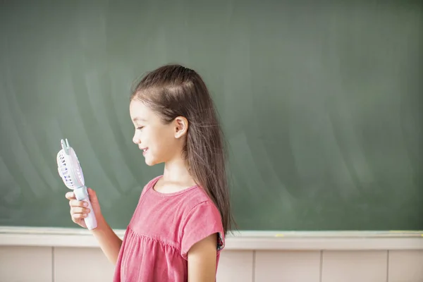 Szczęśliwy szkoła dziewczyna stojący przeciwko tablica tło — Zdjęcie stockowe