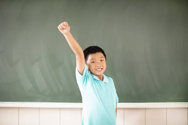 Tebeşir tahtası arka plan karşı duran mutlu okul çocuğu — Stok fotoğraf