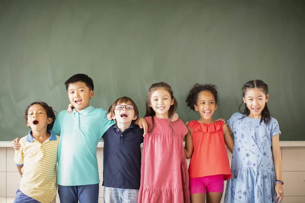 Multietnisk grupp av skolbarn som står i klassrummet — Stockfoto