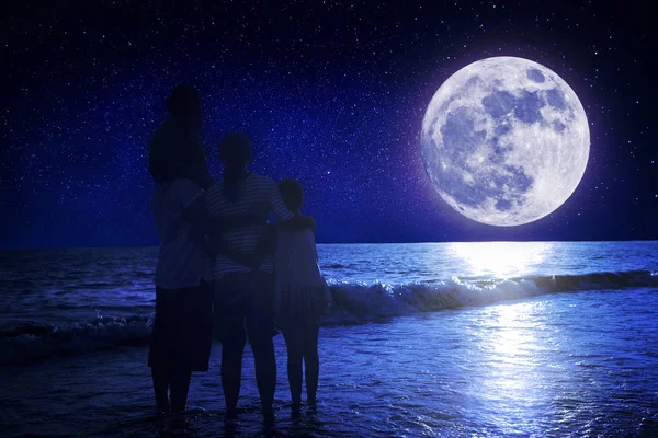 Familia de pie en la playa y viendo la luna.Celebrar Mid-aut — Foto de Stock