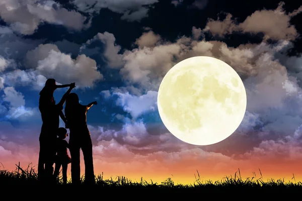 Familie staande op heuvel en kijken naar de maan. Vieren mid-autu — Stockfoto