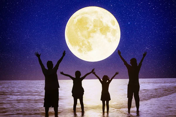 Familie în picioare pe plajă și vizionarea lunii. Sărbătorește mijlocul orașului — Fotografie, imagine de stoc