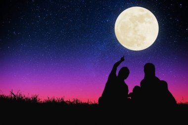 mutlu aile tepede oturan ve ay ve yıldız izliyor . Cel