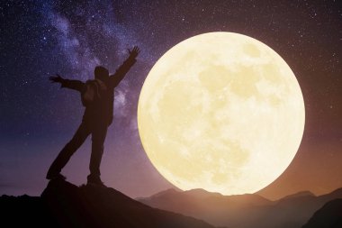 dağda duran ve ay seyreden genç. Orta bir kutlayın