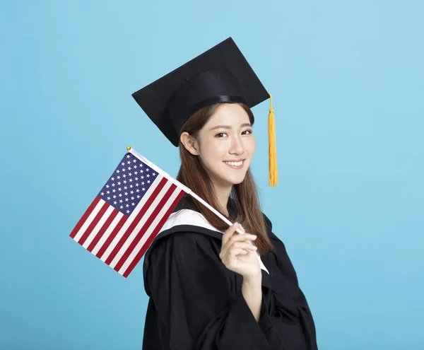 Feliz joven estudiante de graduación femenina mostrando la bandera de EE.UU. — Foto de Stock