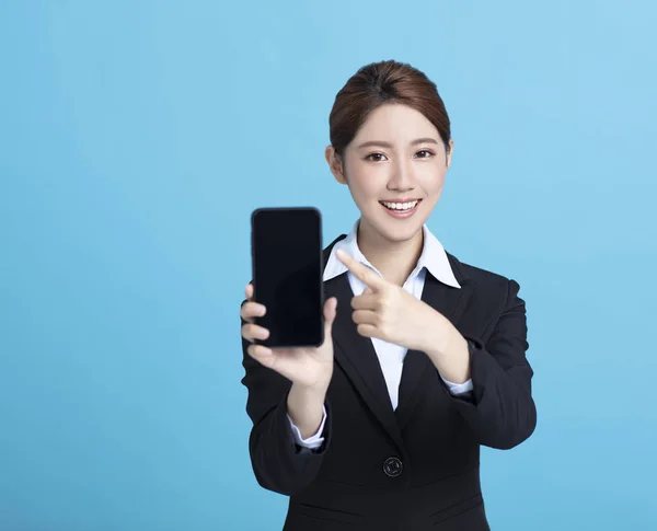 Усміхнена азіатська бізнес-леді показує смартфон — стокове фото