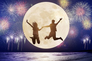 genç çift sahilde atlama ve ay izlerken