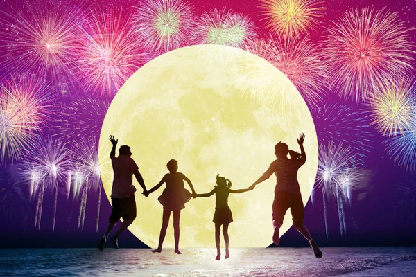 Familjen hoppar på stranden och tittar på månen. Firar semes — Stockfoto