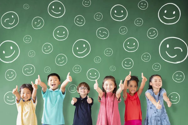 Feliz grupo multiétnico de niños de la escuela de pie en classroo — Foto de Stock