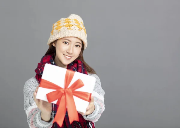 Joven hermosa mujer en ropa de invierno mostrando caja de regalo — Foto de Stock