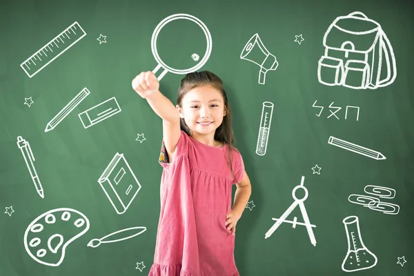 Klein meisje staande tegen schoolbord en onderwijsconcept — Stockfoto