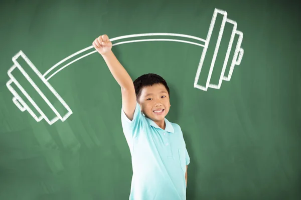 Gelukkig Aziatische jongen staande tegen schoolbord en sterke winnaar concept — Stockfoto