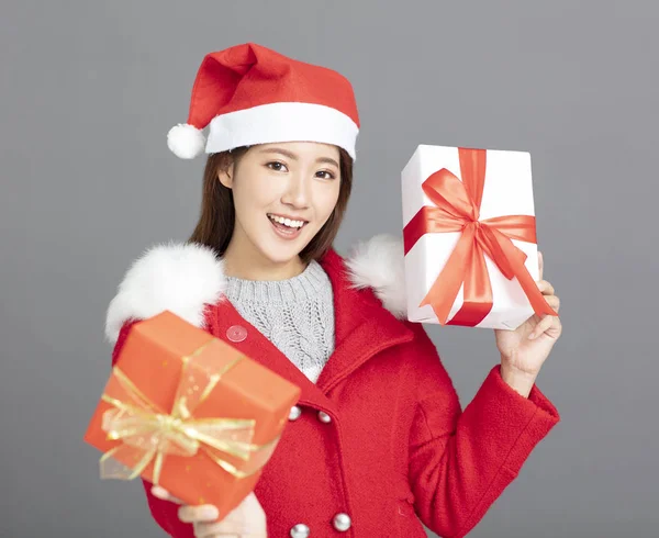 Joven hermosa mujer en ropa de invierno mostrando regalo de Navidad — Foto de Stock