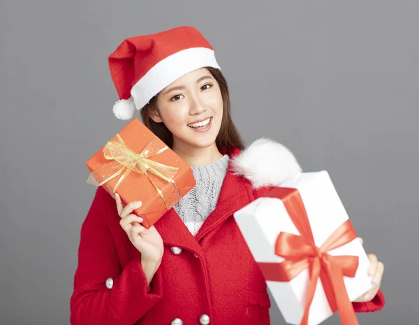 Joven hermosa mujer en ropa de invierno mostrando regalo de Navidad — Foto de Stock