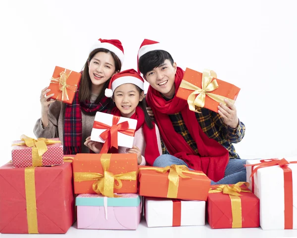 Família feliz sentado no chão e mostrando presente de Natal — Fotografia de Stock