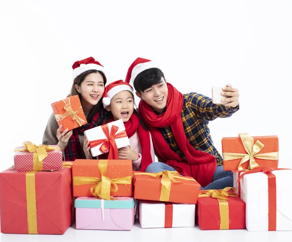 Família feliz tomando selfie e mostrando presente de Natal — Fotografia de Stock