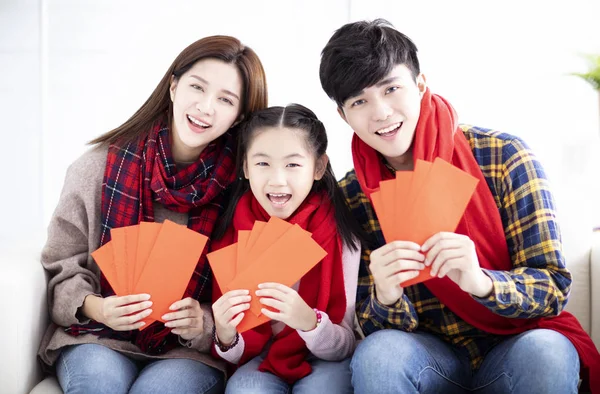 Счастливая азиатская семья показывает красный конверт на китайский новый год — стоковое фото