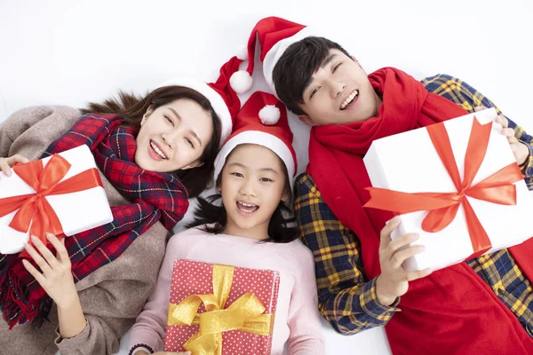 Família feliz deitado no chão e mostrando presente de Natal — Fotografia de Stock