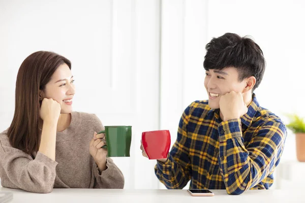 Lyckligt ungt par pratar och skrattar, dricker te. — Stockfoto