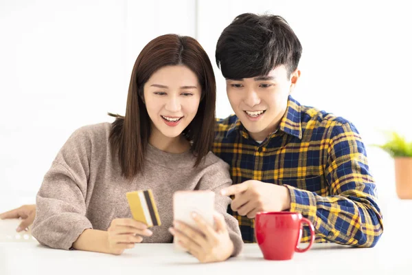 Feliz casal jovem compras on-line por telefone inteligente — Fotografia de Stock