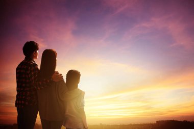 arka görüş aile ayakta ve gün batımını izliyor