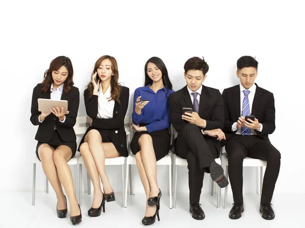 Uomini d'affari seduti sulle sedie e utilizzando lo smartphone — Foto Stock