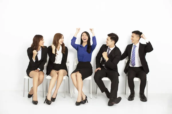 Szczęśliwych azjatyckich ludzi biznesu siedzi na krzeseł z rzędu — Zdjęcie stockowe