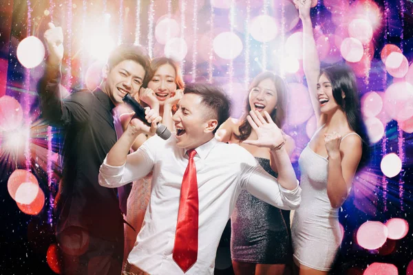 Alegre grupo jovem cantando e dançando em festa — Fotografia de Stock