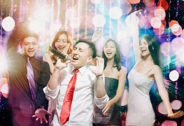 Happy young group singing and dancing in party Stock Photo