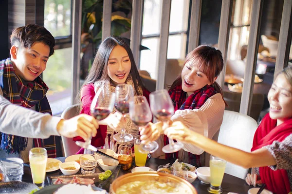 Счастливые друзья веселятся в ресторане с горячей кастрюлей — стоковое фото