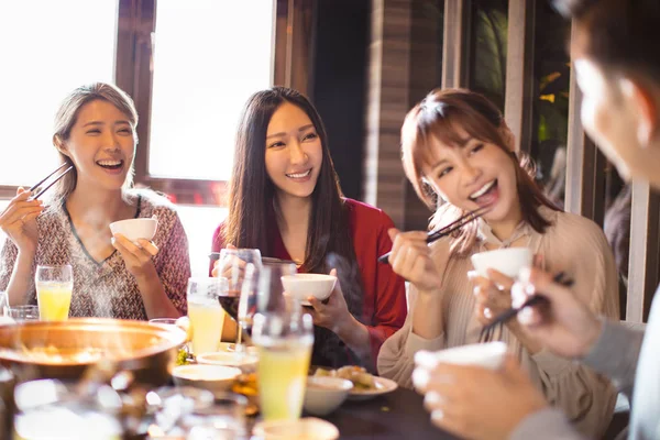 Jovens amigos felizes comendo panela quente no restaurante — Fotografia de Stock