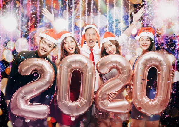 Grupo jovem comemorando novo teixo 2020 na festa de Natal — Fotografia de Stock