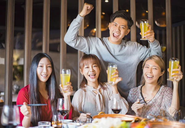 Молодые друзья веселятся в ресторане с горячим горшком — стоковое фото