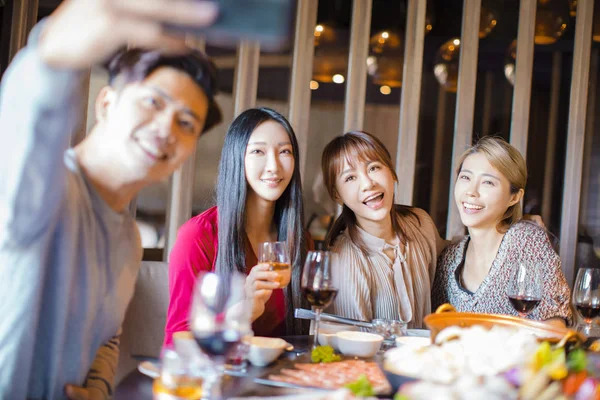 Amigos felizes tomando selfie no restaurante pote quente — Fotografia de Stock