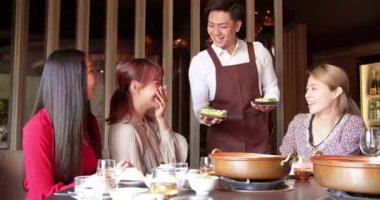 Mutlu garson restoranda servis yapan arkadaş grubuyla birlikte güveç getir..