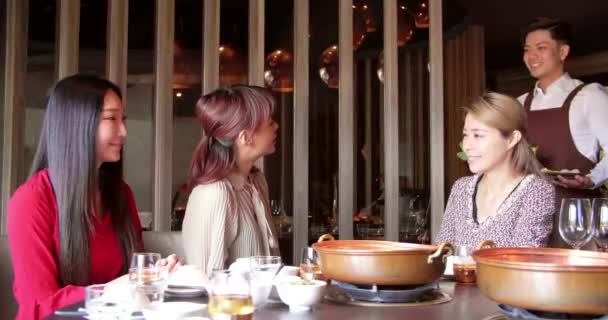 快乐的侍者带着火锅和海鲜在餐馆里招待一群朋友 — 图库视频影像