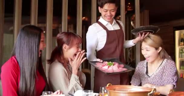 快乐的侍者带着火锅和海鲜在餐馆里招待一群朋友 — 图库视频影像