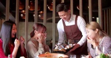 Mutlu garson restoranda servis yapan arkadaş grubuyla birlikte güveç getir..