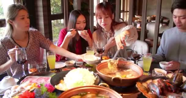 快乐的年轻朋友在火锅餐厅享用晚餐 — 图库视频影像
