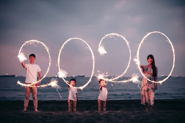 Счастливая семья празднует Новый 2020 год на пляже — стоковое фото
