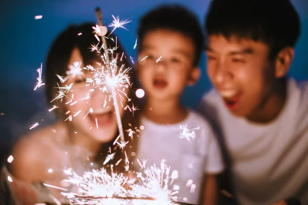 Glad familj firar nytt år med tomtebloss — Stockfoto